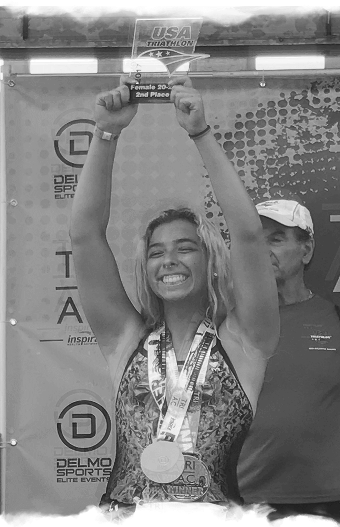 a black and white photo of a woman holding up a trophy